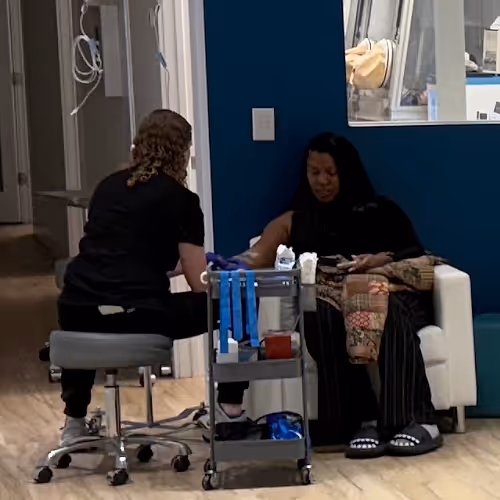 Several clients receive IV therapy in a group setting, each with their own infusion tailored to their needs.