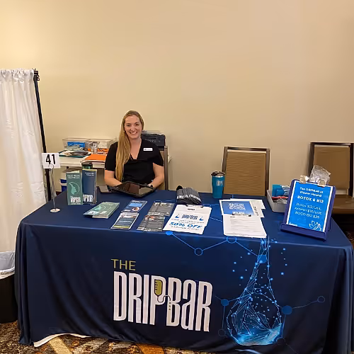 Team members at The DRIPBaR Hammond smiling and welcoming clients, dressed in professional attire, standing in the lounge area.