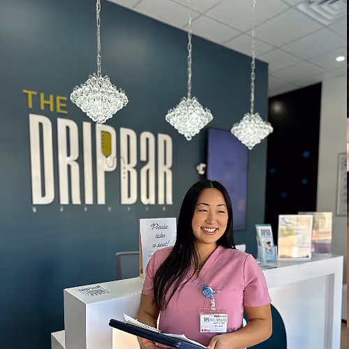 Client checking in at The DRIPBaR Hammond front desk, greeted by a staff member ready to assist with their IV therapy appointment.