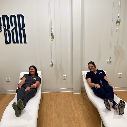 Friendly staff at The DRIPBaR Hammond preparing IV therapy supplies, focusing on professionalism and guest comfort in a welcoming clinic.