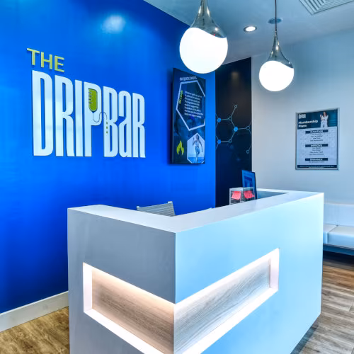 Client checking in at The DRIPBaR Hammond front desk, greeted by a staff member ready to assist with HydraFacial scheduling.